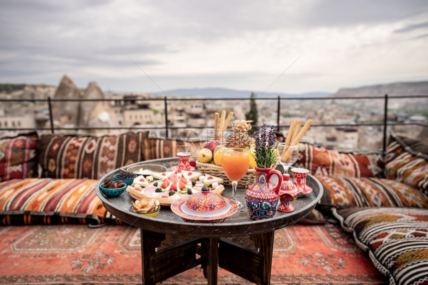 橄榄健康在土耳其卡帕多西亚戈雷梅市洞穴屋顶上与大风景盛的早餐咖啡图片