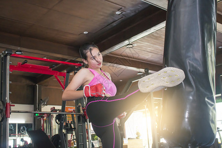 亚裔女在重包上做拳击训练冲床强的合身图片