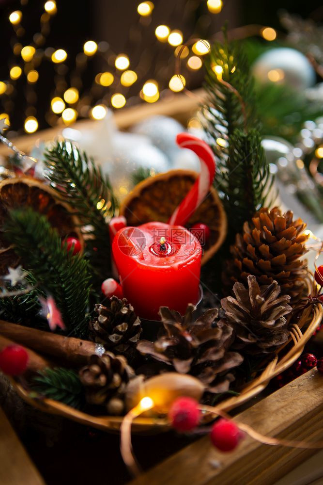 背景中带有冷杉树枝和锥体散景的红蜡烛背中带有冷杉树枝和锥体散景的红色蜡烛圣诞节棕的花圈图片
