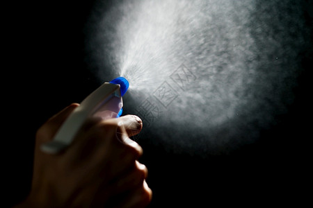 电晕喷涂手使用蓝色雾喷洒消毒剂以停止传播冠状或COVID19图片
