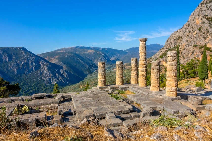 欧洲蓝色的建筑学在阳光明媚的山脉和蓝天空背景下希腊大地震山背景下的希腊古老废墟图片