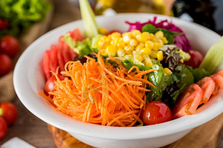 小吃新鲜的盘子混合健康沙拉在木制桌上的白碗中图片