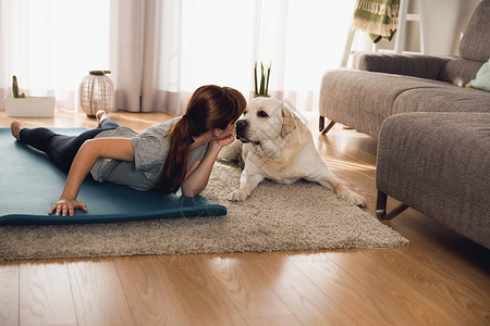 积极的身体击一名妇女与她的狗在家锻炼训练图片