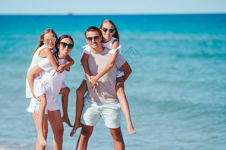女士户外享受暑假海滩上的幸福家庭暑假海滩上的快乐家庭图片