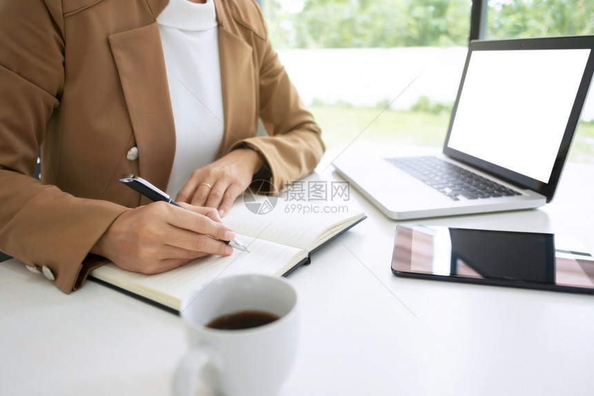 人们现代的网络一名妇女使用笔记本电脑在咖啡厅桌上用空白屏幕拍摄的假照片图片