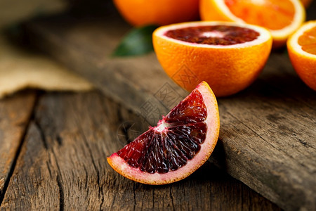 新鲜红色的旧深木质背景上的西里血橙片切柑橘味图片