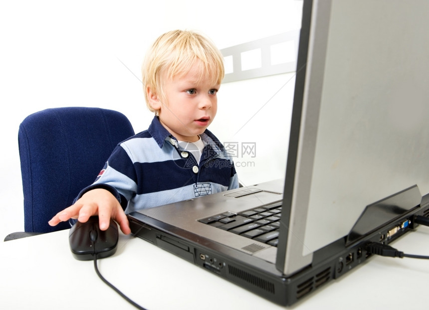 教育沉思的一名男孩坐在个小的座位上使用笔记本电脑他从胸部向上可以看到他正在离膝上电脑屏幕的相机看远一点横向图片