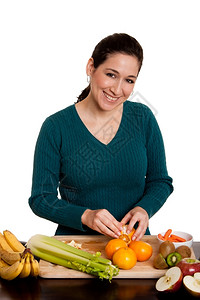 美味的木板厨房里美丽的快乐女人在厨房里剥橙子准备果汁或沙拉的水维他命图片