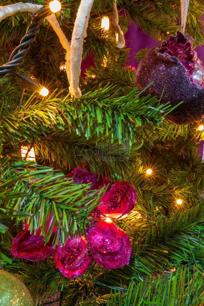 内部的球紧贴一棵圣诞树在紫色主题下装饰有突出的紫色石榴和挂花装饰庆祝图片