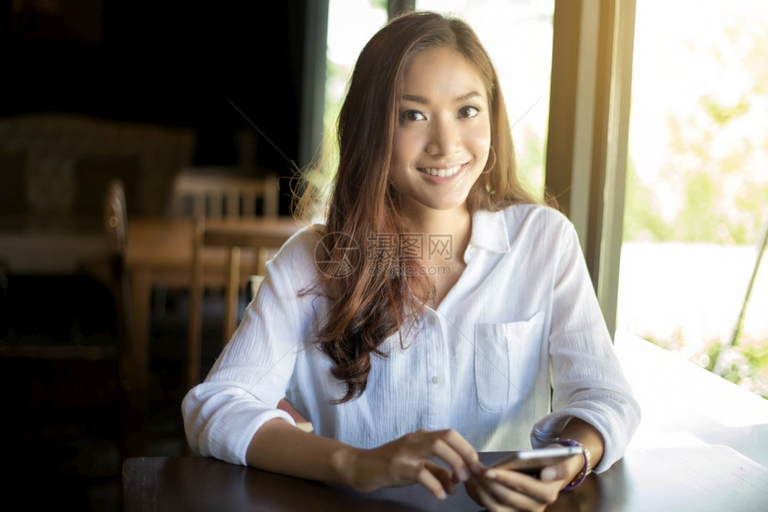 亚洲男女商人正在使用移动和触摸智能电话进行通信并检查办公室背景的商人情况亚洲男女商人正在使用移动和触摸智能电话女士应用程序年轻的图片