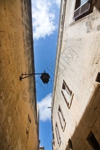 旋钮旅游在马耳他Mdina的阳光明媚一天旧建筑和城墙内的蓝天空正面图片