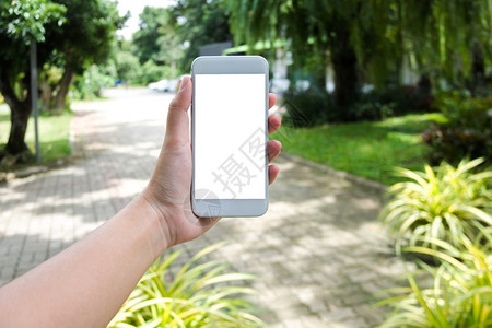 白色屏幕保持手空白屏幕的握着模糊背景的移动智能手机妇女有创造力手指背景