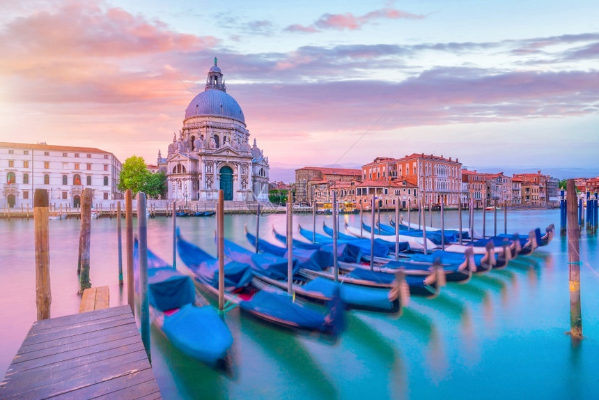 浪漫的旅行在意大利威尼斯的运河圣玛丽亚德拉萨卢特巴西利卡在黄昏时的背景中吸引力图片