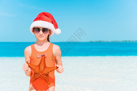 明信片可爱的圣诞快乐小孩在海滩上过圣诞假期孩子在海滩上过圣诞度假戏服图片