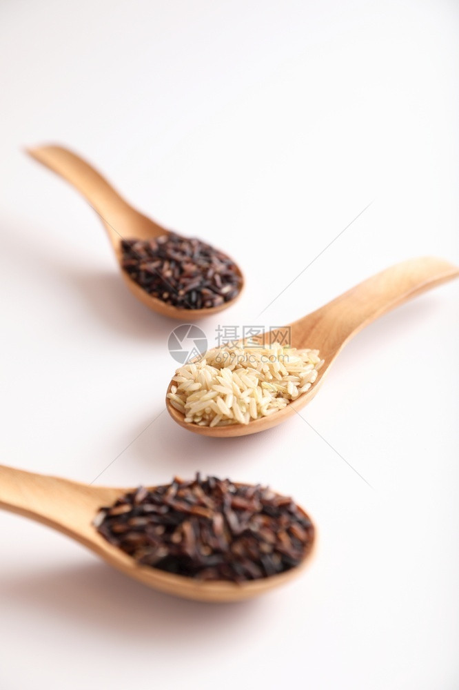 有机生棕褐大米和近距离在勺子上煮饭的稻草泰国自然干燥图片