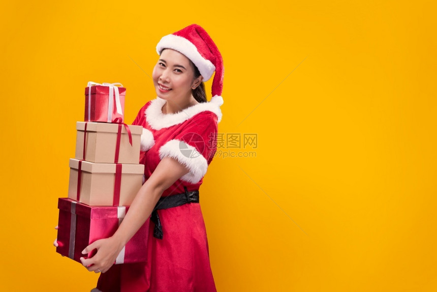 假期淑女孩圣诞快乐和新年的时候一个穿着圣诞老人服装的美女带着许多礼物盒的美丽女人图片