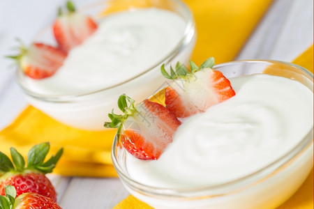 清楚的饮料普通酸奶加美味新鲜草莓玻璃图片
