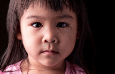亚洲女童在黑暗背景中充满信心的亚洲小女孩脸部肖像表象快乐的自信情感图片