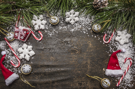 带有糖果帽子装饰品和绿松树枝及圆锥形顶部风景的圣诞雪底分支庆典下的图片