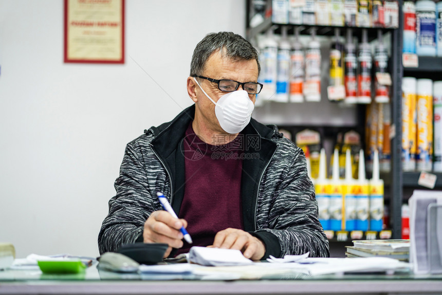 对身戴眼镜的高级天主教男子的肖像他们戴着保护面罩以其免受流感抗菌保护问题的感染工作场所商店销售创业者流行于工作场所白种人发烧细菌图片