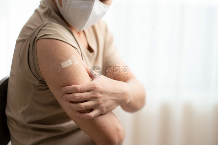 注射疫苗后佩戴口罩的男子将手臂露出图片