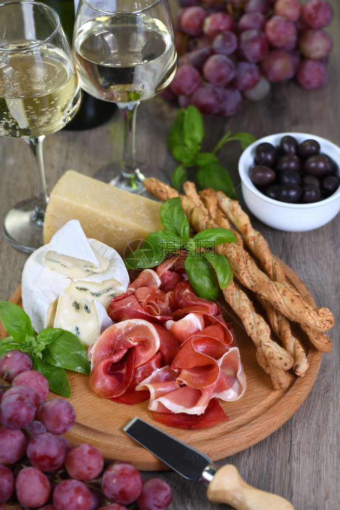 干火腿带霉菌的卡门贝尔奶酪带格里西尼的帕尔马干酪橄榄和粉红葡萄的开胃酒套装小吃营养盐渍的午餐图片
