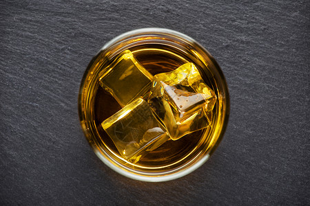 寒冷的玻璃立方体圆杯威士忌和冰在黑色背景从上方的黑底照圆杯威士忌和黑底面的冰图片