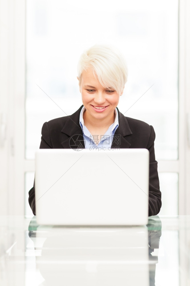 成人笔记本电脑年轻的女经理在其办公室的笔记本照片图片