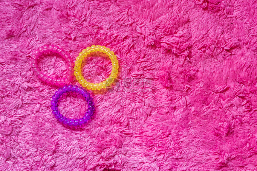 生动明亮的三种不同颜色塑料电缆毛发动画片以粉红背景隔离女孩发型附件乐队图片