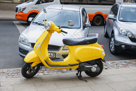 黄色摩托车滑板车拉脱维亚里加市RetroScooterVespa街黄色城市观点2018年摩托车传统的背景