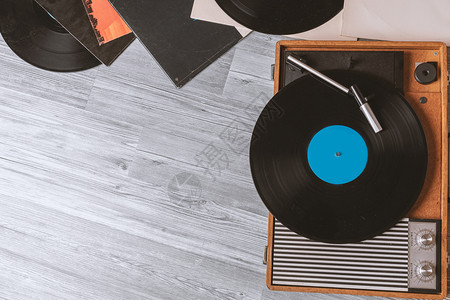 唱片人光盘复古的在灰色木制桌顶视图和复制空间上有黑乙烯胶唱片的旧式喇叭记录设计图片