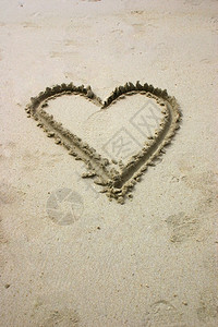 水平的乐趣在海滩上沙中用手写下心海洋图片