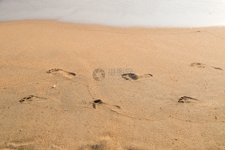 自由步行海滩背景上父亲和孩子的脚印页赤图片