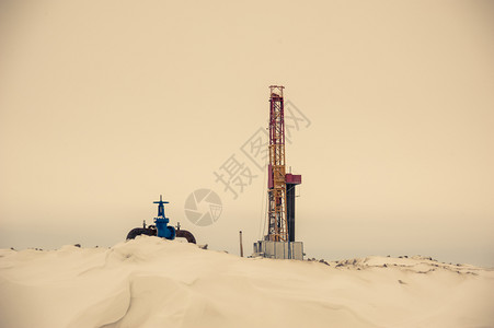 管道汽油井架冬季田中的石钻机和井口气概念田中的石钻机和井口图片