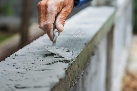 工人紧的手在打石膏抹灰工匠镘图片