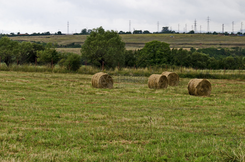 庄稼稻草大包保加利亚Dupnitsa镇附近的山地前面有圆干草田和环林图片