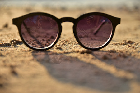 蓝色的眼镜太阳在沙滩上假期图片