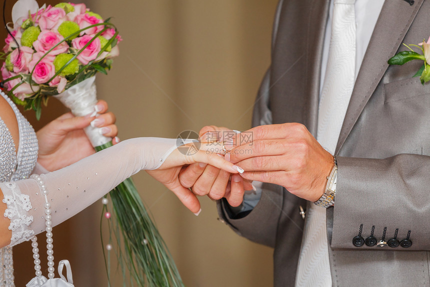人类新郎在娘结婚仪式交换戒指戴婚的手上戴订婚戒指新郎还戴着订婚戒指承诺图片