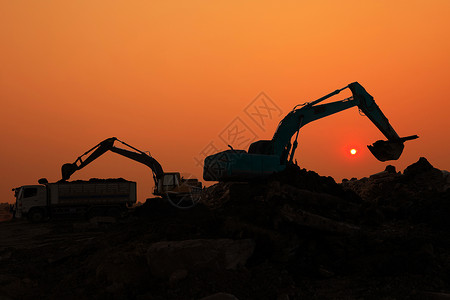 挖核器活动土壤日落天空下建筑工地挖土机装载器的轮光铲背景