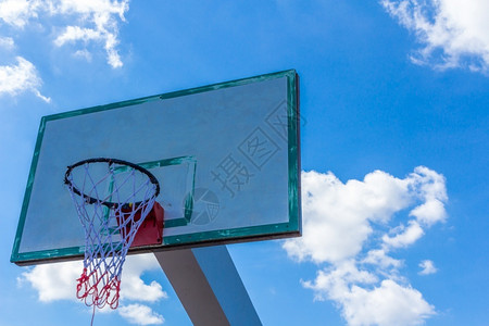 运动训练蓝天空和云彩上的篮球圈轮缘图片