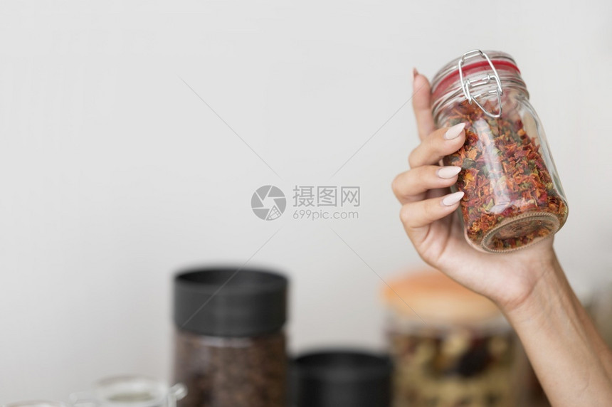 自制妇女拿着罐子配有香料和复制空间的玻璃图片