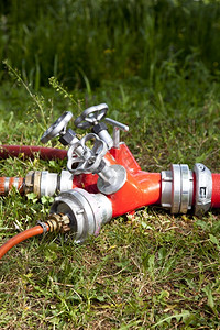 喷连接草丛外的若干消防水管压力火焰图片