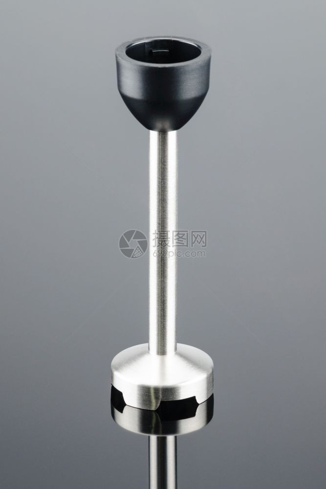 旋钮配饰灰色镜面背景上黑塑料电动手搅拌器的脚复制空间灰色镜面背景上的搅拌器脚转变图片