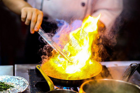 手工具气体厨师在房炉灶的煎锅中用火焰做饭图片