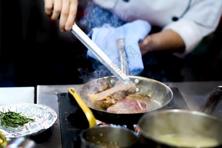 服务盘子厨师在房炉灶的煎锅中用火焰做饭气体图片