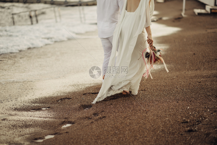 新娘新郎在沙滩上散步图片