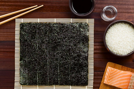 上海话碶饭床单海鲜寿司成料木须竹垫上海藻用于滚动筷子酱油大米醋生寿饭和新鲜鲑鱼对寿司成分顶部拍照背景