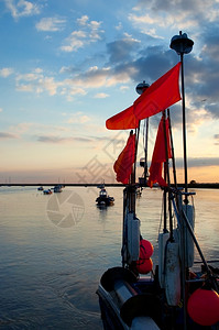 海严厉渔船尾的日落颜色多彩晚上图片