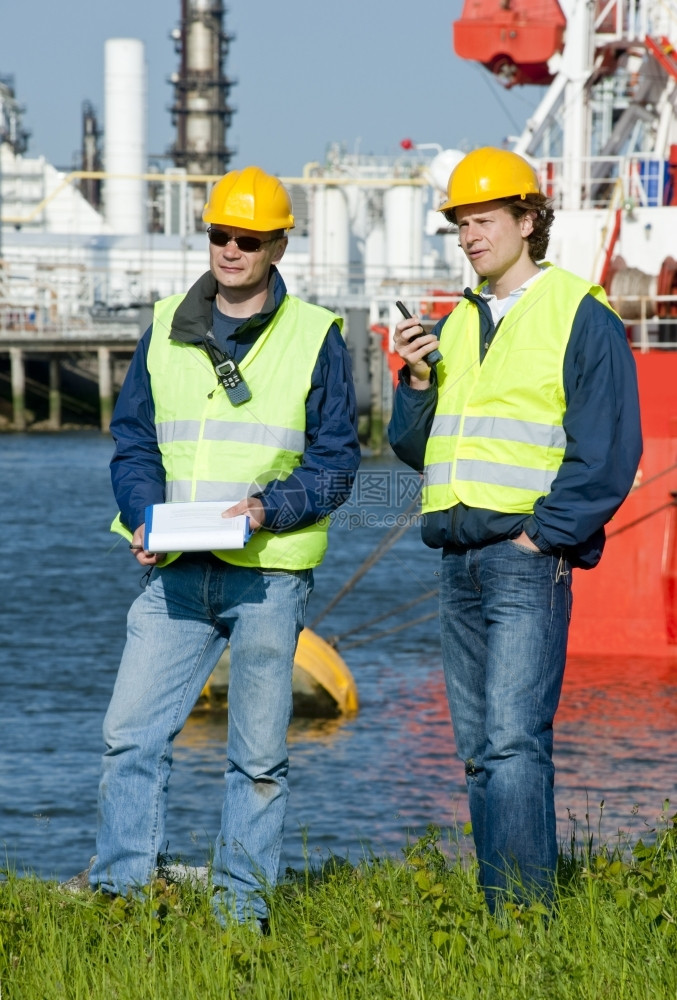 同事两名港口工程师配有无线电个人安全设备和一个剪贴板工业的进口图片