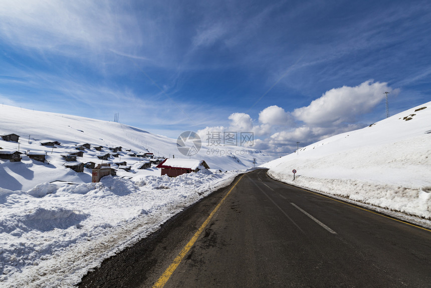 云高速公路山景和地房屋在雪中沥青图片